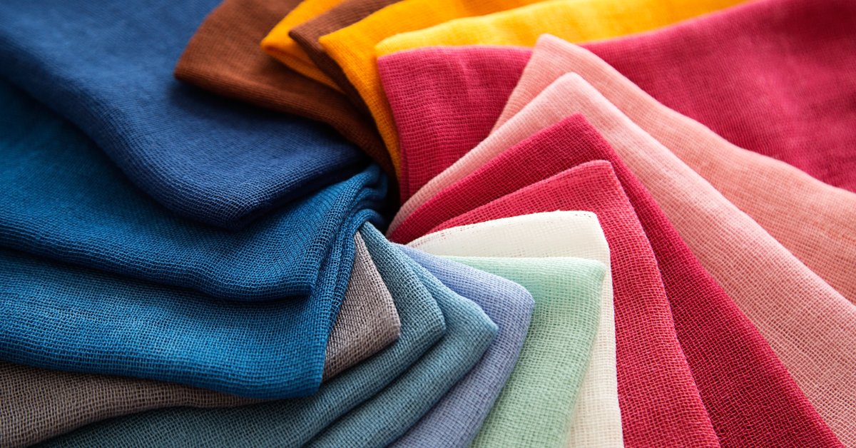 A bunch of pieces of cotton in differently colors rest on each other in a circular spiral formation.